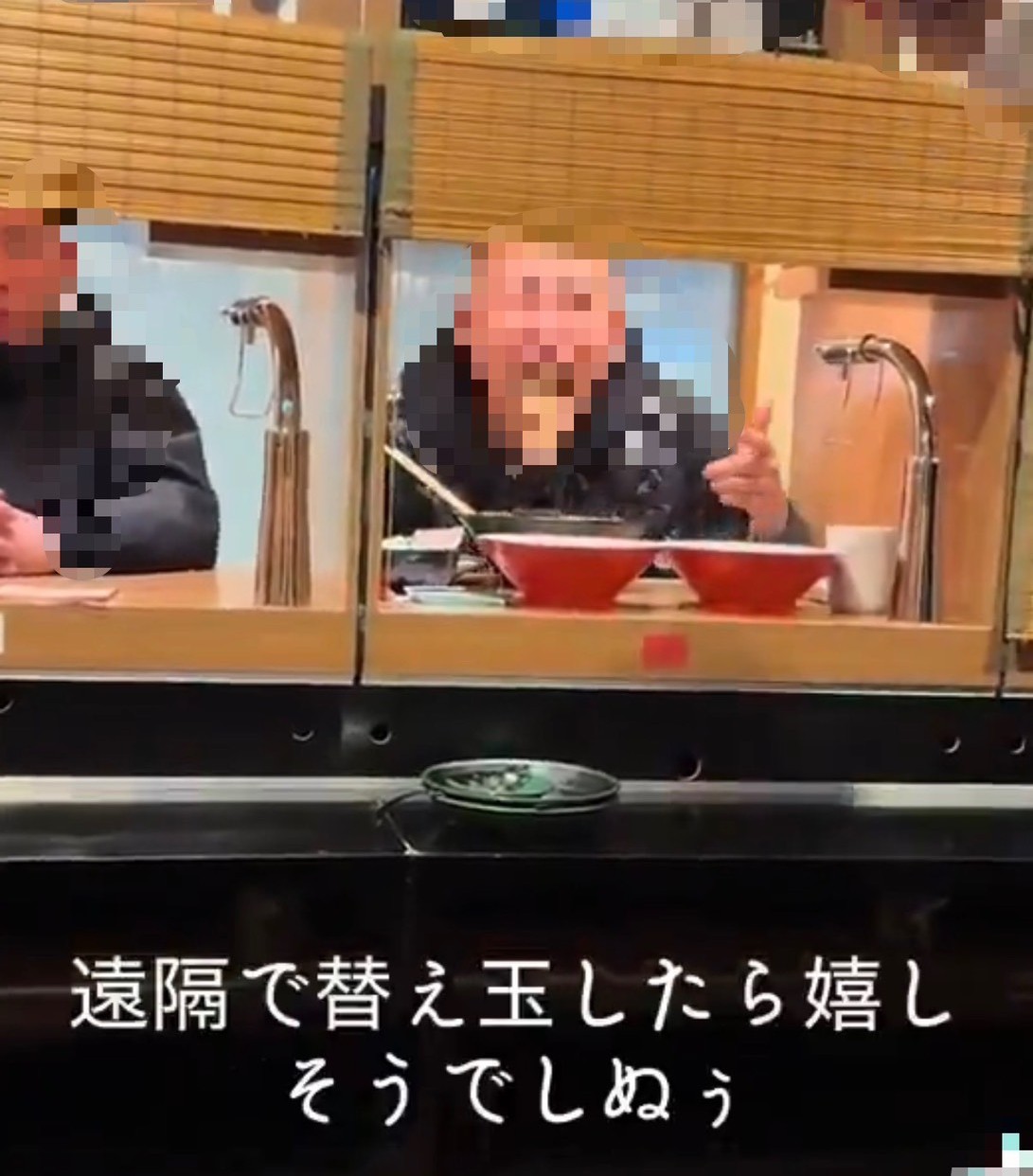 一蘭とみられるラーメン店のカウンター席で、男性客が麺を口元に含んでいる動画の一場面