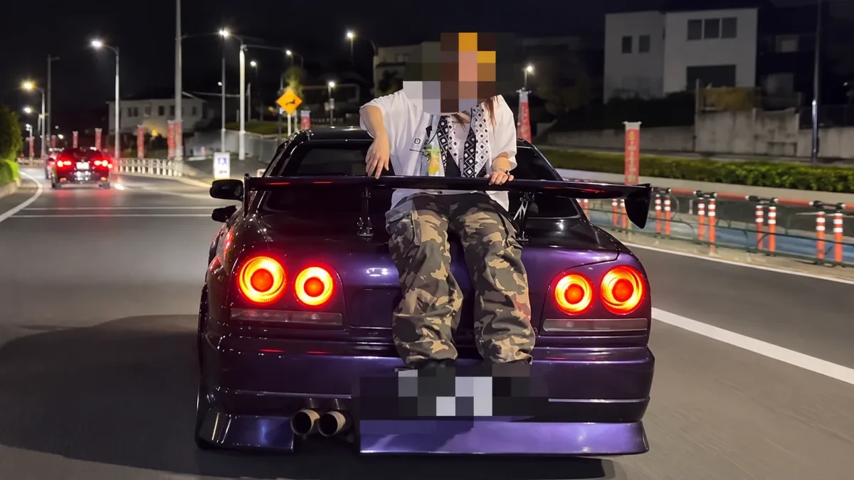 改造スポーツカーの車体後部に人物が座る様子を捉えた画像。個人情報保護のため一部にモザイク加工